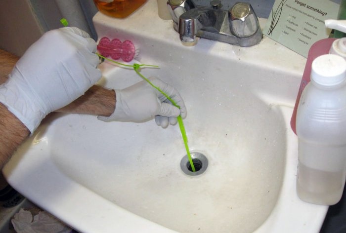 Curățarea chiuvetei și a scurgerii căzii cu un dispozitiv de șapă din nylon